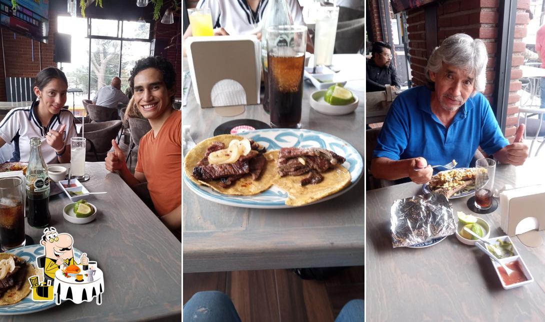 Dos comensales sentados a una mesa junto a las ventanas del restaurante.